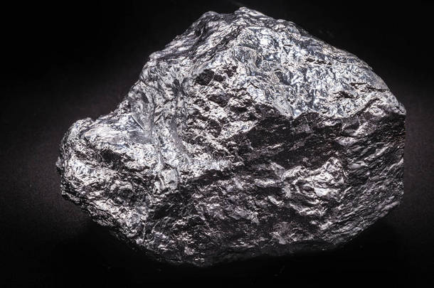 铝石在孤立的黑色背景。铝是一种化学元素，在室温下是固体，是地壳中最丰富的金属元素.