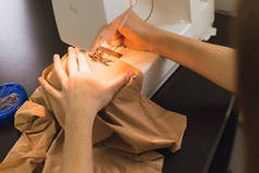 缝纫机上有缝纫机。 这个女孩缝制并拿着一块粉红色的布