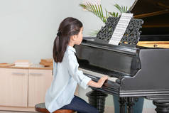 小女孩在家里弹大钢琴