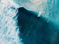 与冲浪者的空中景色，以及在水晶海洋中的波浪。 顶部视图