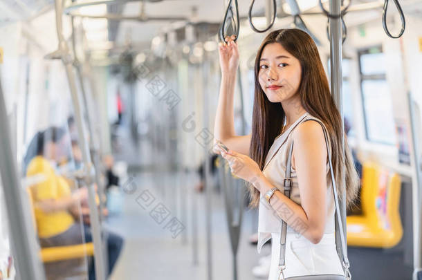 在大城市、日本人、中国人、韩国人的生活方式和日常生活、通勤者和交通观念中，年轻的亚洲<strong>女性</strong>乘客在乘坐地铁时，通过智能<strong>手机</strong>使用社交网络