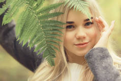 生态概念女孩肖像蕨类，年轻的成年模特金发碧眼，绿叶在脸上