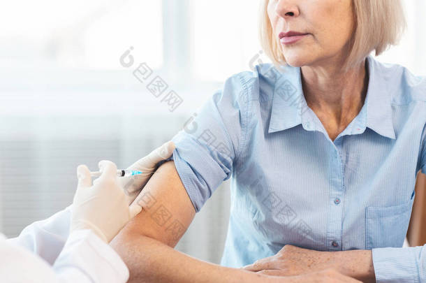 为老年妇女接种疫苗的产科病房护士