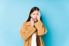 年轻的中国女人穿着蓝色的背景，孤独地呻吟着，悲伤地哭泣着.