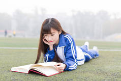 可爱的中国女高中生在校园操场上学习
