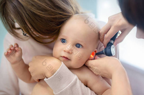 儿科医生用耳镜检查<strong>儿童</strong>的耳朵.妈妈用手抱着孩子医药，医疗保健，儿科和人。<strong>儿童</strong>保健和疾病<strong>预防</strong>概念 .