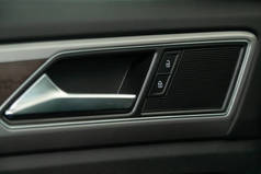 在一辆新车上的门控面板的特写。扶手休息与窗口控制面板，门锁按钮