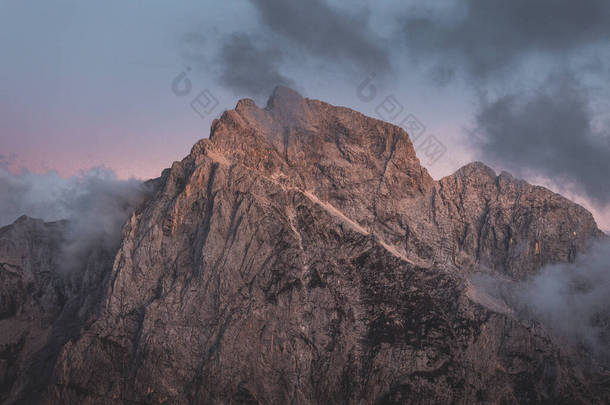 背景照片:高山山谷中的低云,生机勃勃的蓝色和橙色粉红的天空.日出或日落的景色,可以看到群山和山峰在云中的最高峰.斯洛文尼亚阿尔卑斯山脉冬季高山景观