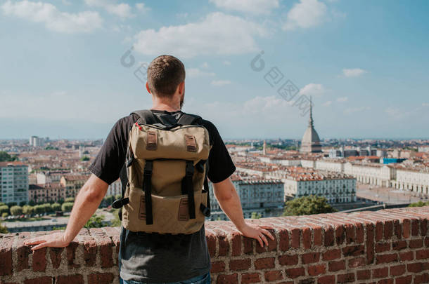 背包客欣赏都灵的全景。在Mole Antonelliana的迷人风景。探索皮蒙特，意大利。城镇和山区。城市景观，古老的历史建筑。旅行、冒险、生活方式