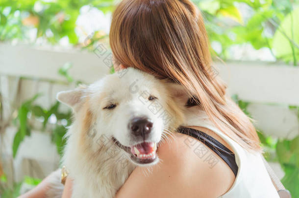 女人拥抱着她的宠物狗，亲密的宠物狗，快乐和友谊。宠物和女人.