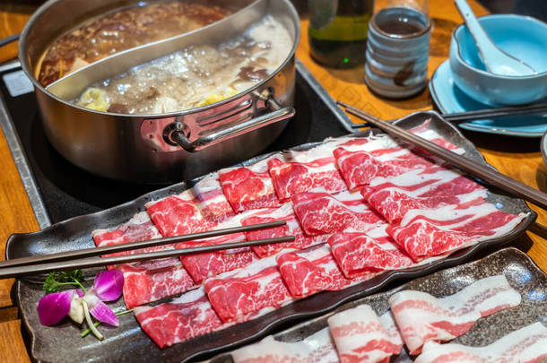 选择在火锅餐厅烹调的肉盘，包括牛肉、羊肉和猪肉。所有薄片为快速烹调。汤在火锅里沸腾