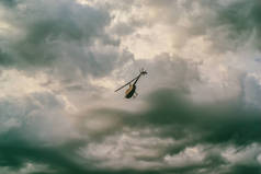 一架大直升机在多云的夏日天空下飞越天空