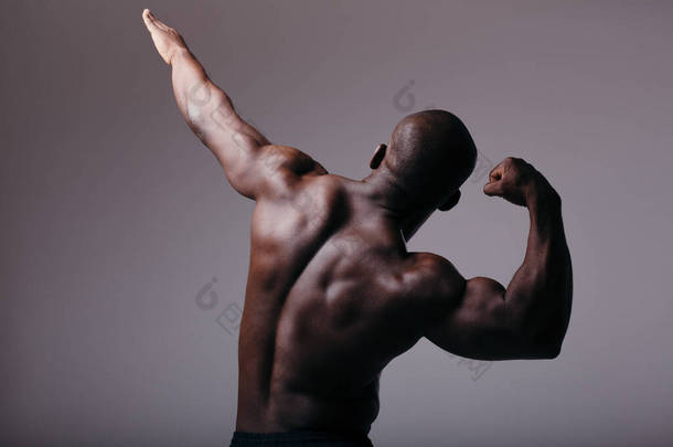 后视镜男人的膨胀回来了。非洲男人表现出<strong>肌肉</strong>，举起一只<strong>胳膊</strong>