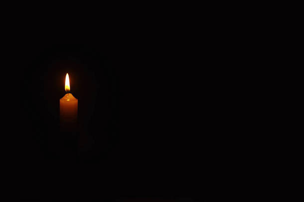 燃烧着的蜡烛在燃烧的火焰中从蜡烛上吹来.悲伤和孤独的象征。一个哀悼的时刻。燃烧蜡蜡烛。宗教.