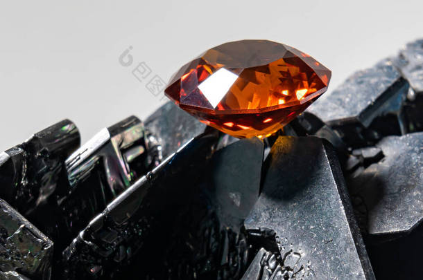 一张帕德沙彩色刚玉宝石的照片，切割成纺纱机的形状，放在黑色碳化硅表面