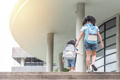 与女童（小学生）一起带着背包回到学校教育的概念，第一天就跑去上课，愉快地走上楼梯间