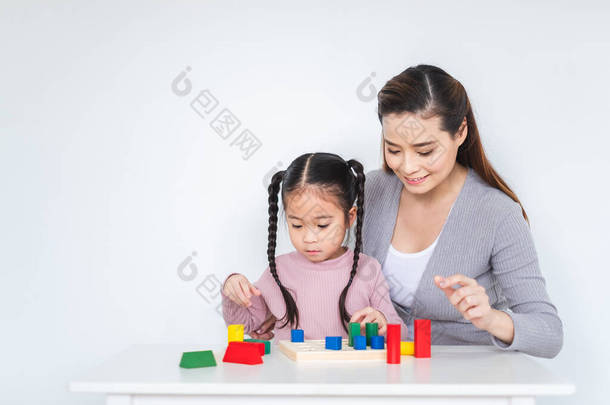 亚洲女孩和母亲玩<strong>方块</strong>玩具，<strong>背景</strong>是<strong>白色</strong>的，家庭观念是幸福的
