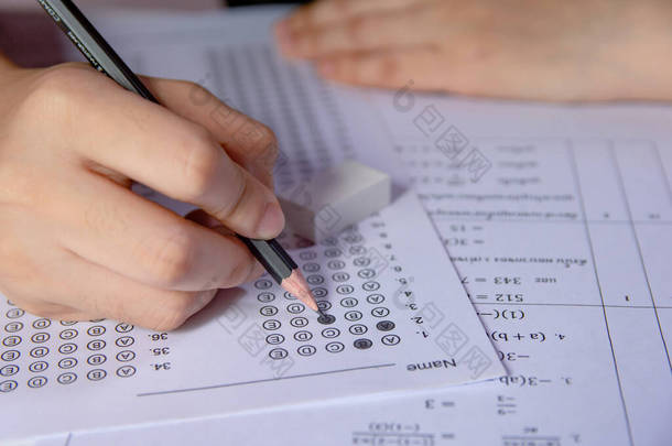 学生们手握铅笔，在答题单和数学试卷上选择写作选项。通过考试的学生。学校行政a