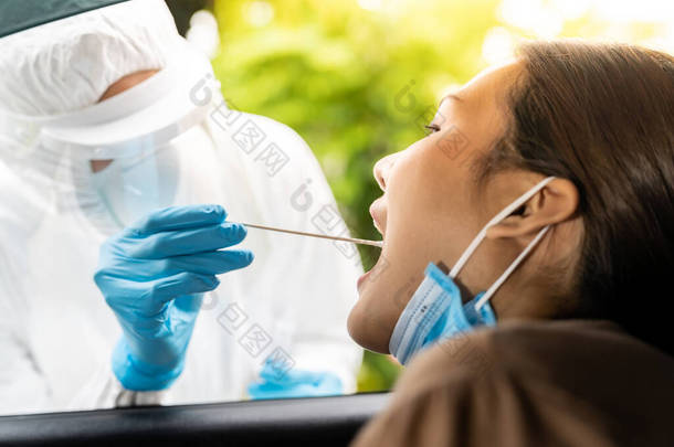 亚洲女人的肖像是医护人员用喉部擦拭的PPE西服，通过考维兹-19测试。新的正规医疗服务和医疗理念.