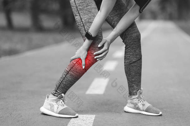 运动创伤。<strong>小腿</strong>受了伤的女慢跑者在室外<strong>按摩</strong>疼痛的腿肌肉