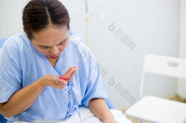 坐在病床上出现血友病症状的亚洲女性患者.