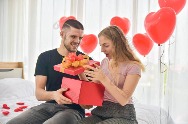 爱的夫妻在卧室里赠送礼品盒快乐的爱的情人节观念