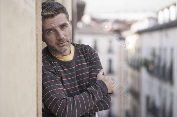 城市生活情景喜剧40多岁英俊男子伤心沮丧在家里阳台斜倚着心烦意乱忧心忡忡忧心忡忡忧心忡忡看着城市街道思考问题