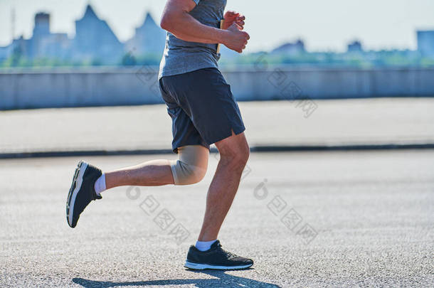 跑步的人运动员穿着运动服在城道上慢跑.健康的生活方式，健美的运动爱好。街头运动，户外运动