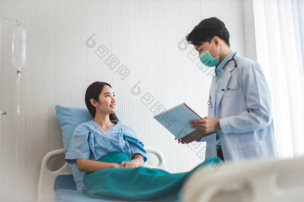 医疗和保健概念。亚洲医生正在医院照顾病人的妇女。医生或护士戴着防护面罩检查，并把感染眼镜蛇的人带走 .
