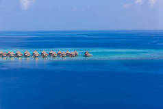 马尔代夫群岛惊人的空中景观。从无人飞机或飞机上完美地看到蓝色的大海和珊瑚礁。异国情调的夏季旅行和度假景观,水上别墅和平房.奢华的度假胜地异国情调的目的地自由、逃跑的概念