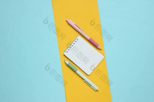 带笔记本电脑的钢笔，<strong>蓝色黄色背景</strong>的特写。色彩斑斓