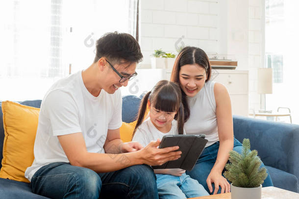 快乐的亚洲家庭，使用平板电脑、笔记本电脑、手机看电影、放松家里的<strong>科技生活</strong>理念