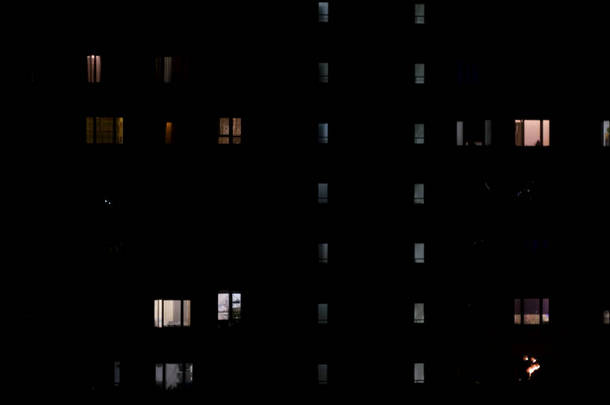 多层大楼窗户内灯光的夜景。概念。多层建筑，深夜有公寓，夜生活的概念.