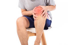 疼痛的膝盖。扭伤和关节炎症状。中年男人把受伤的膝盖抱在白色的背景上.