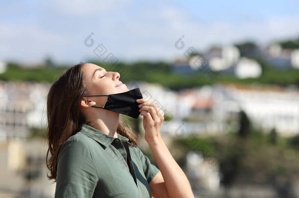 松了口气的女人摘下面具，在镇上度假时呼吸新鲜空气
