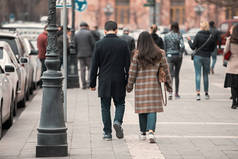 A couple walk along a city bckgroun