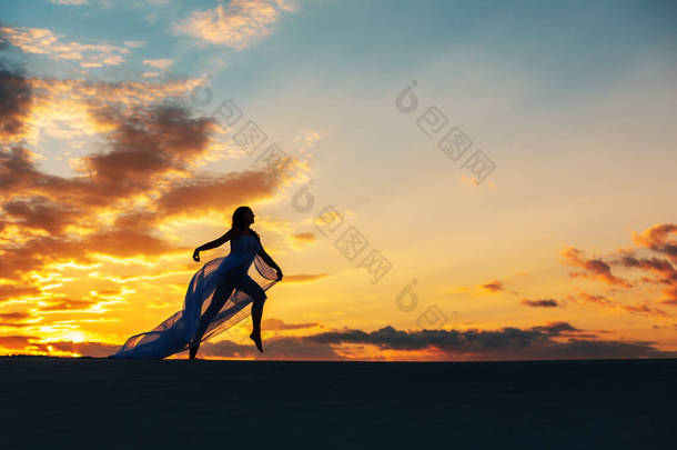 落日<strong>的</strong>时候，一个穿着苍蝇白色衣服<strong>的</strong>女孩在<strong>沙漠里</strong>跳舞和摆姿势.