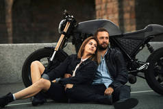 2.在这个城市里，美丽的一对恋爱中的自行车情侣正坐在摩托车旁边