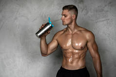 肌肉男从金属振动器中摄取乳清蛋白或其他运动补充剂