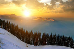 山顶的冬季风景，多雾的山谷，在五彩缤纷的夕阳西下，岩石群山的夜空下.