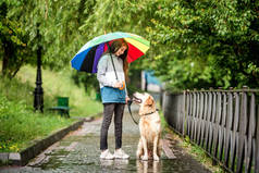 小女孩和狗在雨中散步