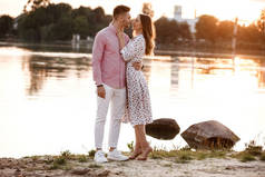 夕阳西下的时候，这对恋人在湖面上互相凝视。美丽的年轻夫妇在夕阳西下，在湖畔漫步，沐浴着灿烂的光芒。复制空间.