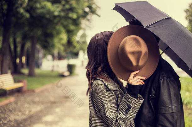 在<strong>城市</strong>公园散步，用<strong>雨</strong>伞遮<strong>雨</strong>的年轻夫妇的画像。异性恋情人有一个约会，在阴天的<strong>雨</strong>天在一起，表现出感情.