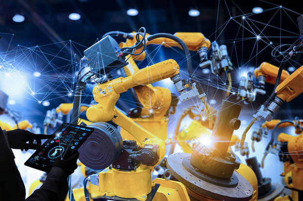 工厂的女工业工程师在<strong>智能化</strong>工厂的自动化机械臂机器上进行实时监测系统软件的工作。数字未来制造.