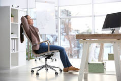 在工作场所的办公椅上休息的年轻女性