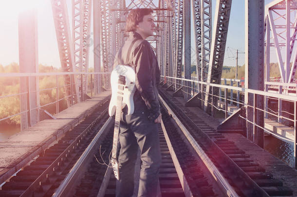 一个在铁路上用电<strong>吉他</strong>的人。一个音乐家穿着皮夹克, 在工业区的街道上拿着<strong>吉他</strong>。<strong>吉他</strong>弹奏者在桥梁