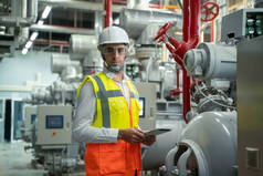 Mechanical maintenance technician inspecting pressure gauge of h