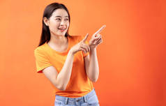身穿橙色背景T恤的年轻亚洲女性形象