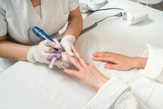 美容师用指甲文件给美容师在美甲沙龙里修指甲的女人。美及手部护理特写.