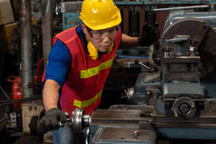 熟练的工厂工人或工程师在制造车间做机器工作